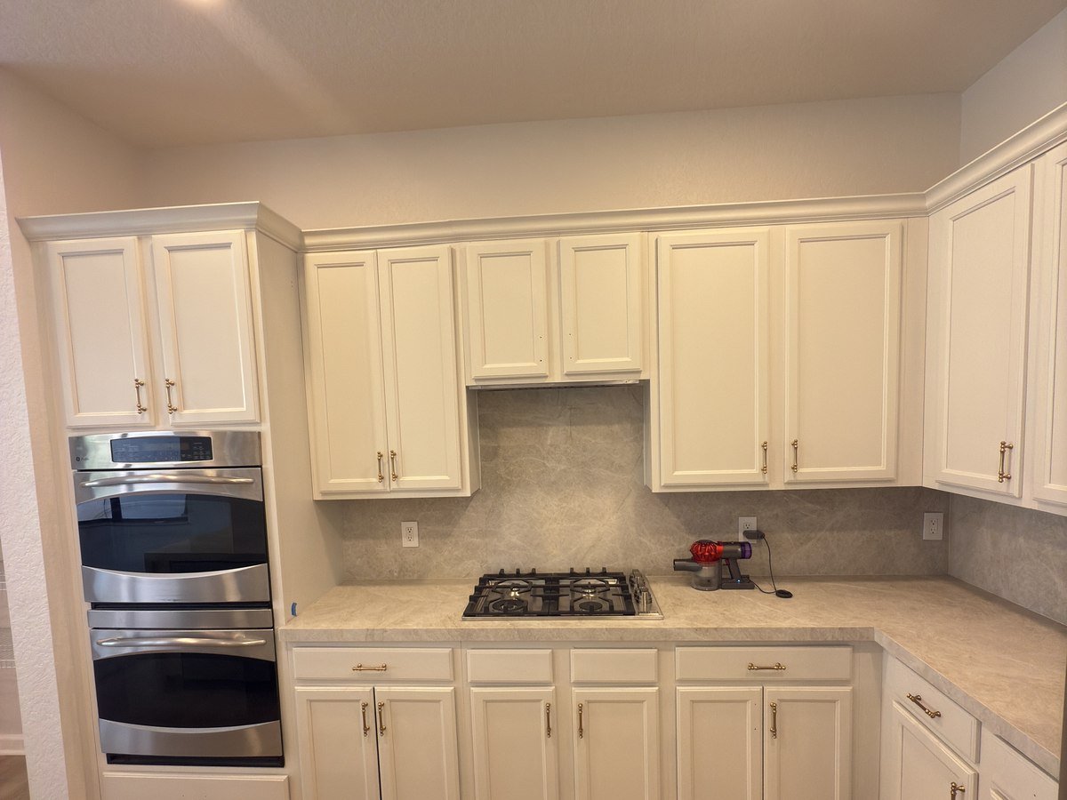 Kitchen remodel with white cabinetry, double wall oven, and gas cooktop