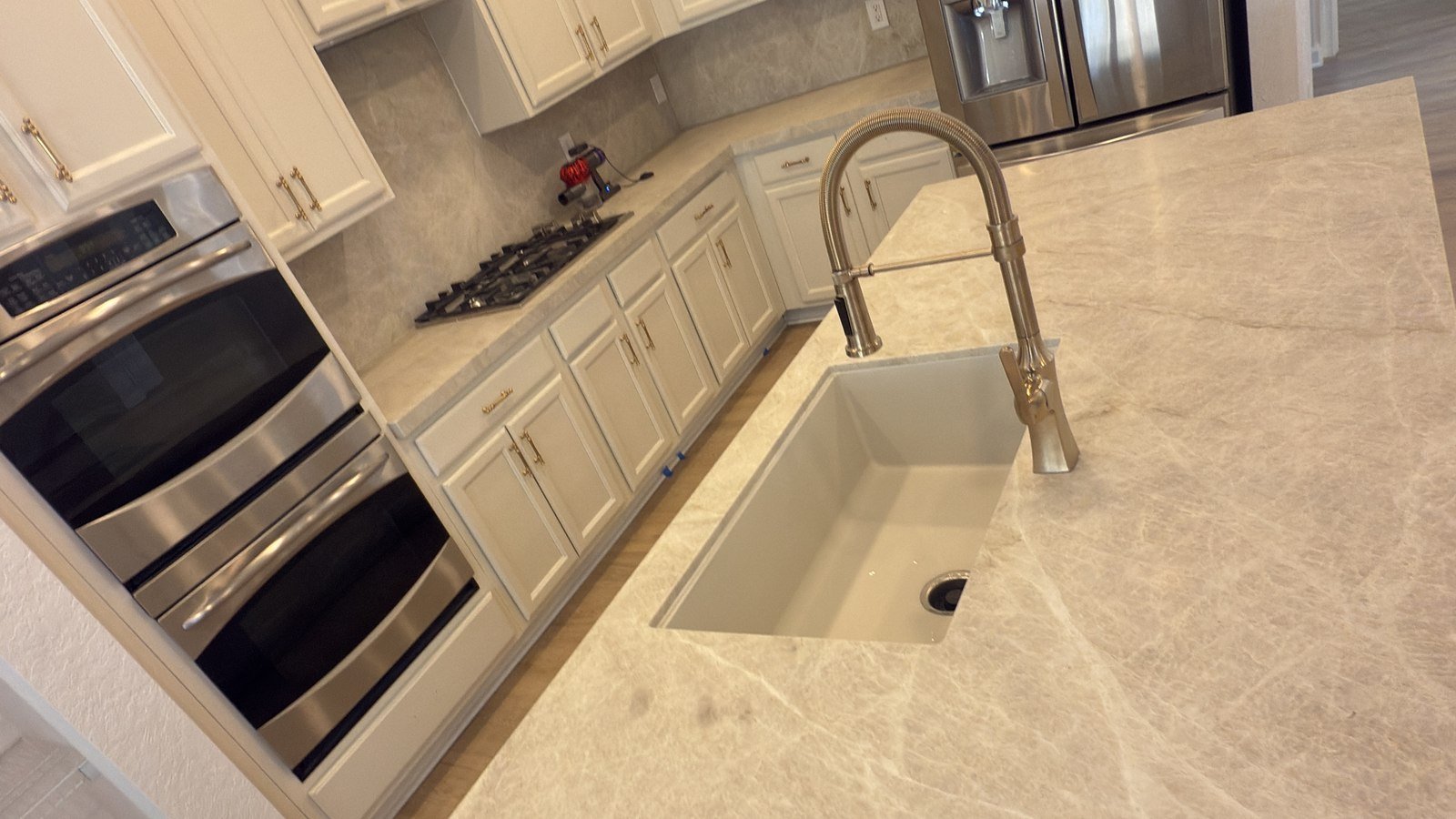 Kitchen remodel with large island, undermount sink, and stainless refrigerator